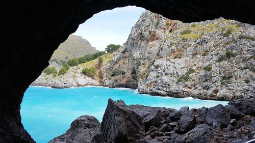 Blue sea against rocky mountain in cave