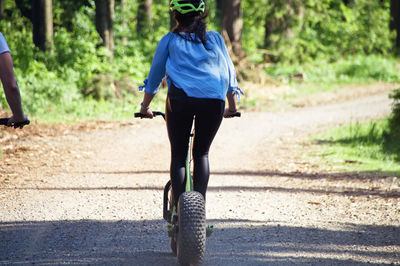 Woman riding push scooters on footpath