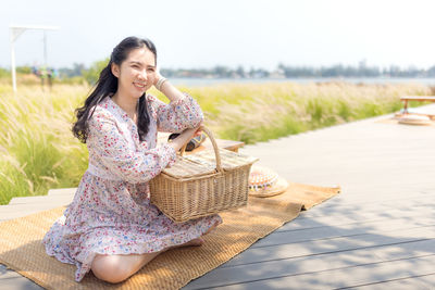 Young woman smiling while sitting in basket