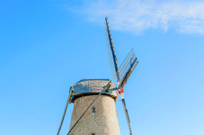 Low angle view of traditional windmill against blue sky