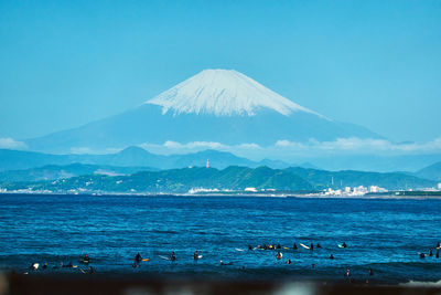 Scenic view of sea and mountain against blue sky