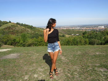 Full length of young woman standing on grass