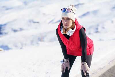 Portrait of young woman standing on snow