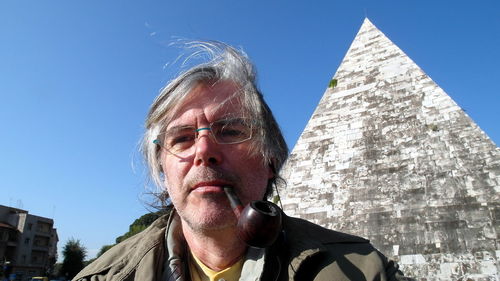 Portrait of man smoking pipe cigarette against clear sky