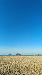 Scenic view of beach against clear blue sky