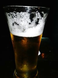 Close-up of beer glass against black background