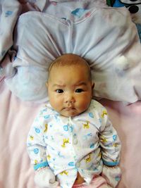 Close-up portrait of cute baby boy on bed