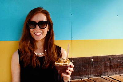 Portrait of smiling young woman with ice cream