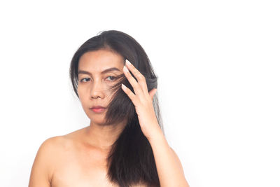 Portrait of shirtless young woman against white background