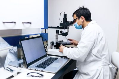 Male scientist using microscopy in laboratory