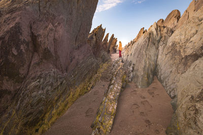 People on rock formations against sky