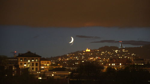 Illuminated city against sky at night