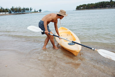 Rear view of woman kayaking in lake