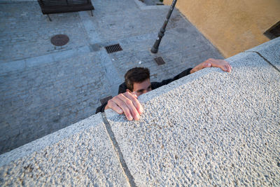 High angle view of man climbing on wall