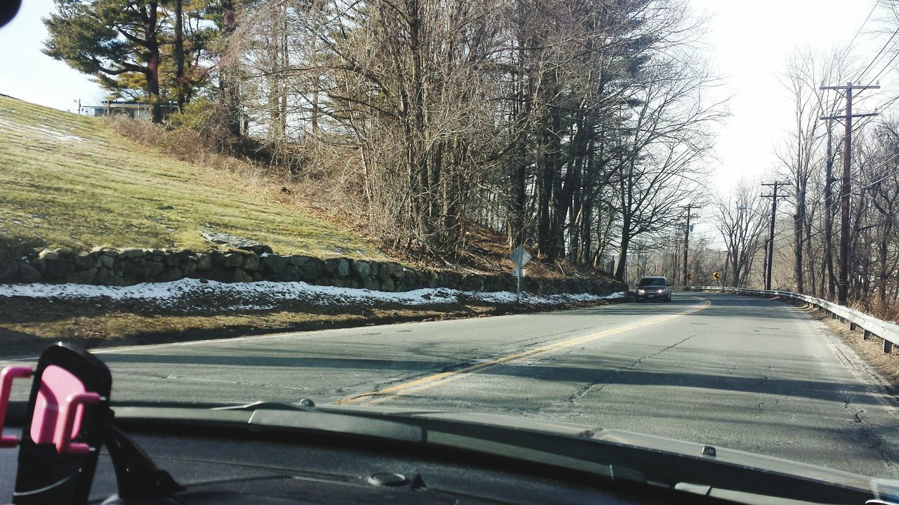 CLOSE-UP OF CAR MOVING ON ROAD AGAINST SKY