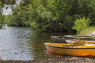 Boat moored in lake against trees