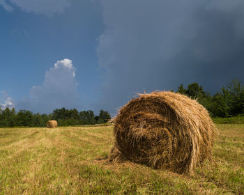 Hay bales on field against sky