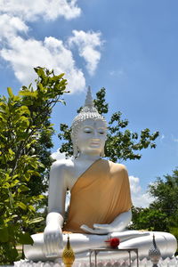 Low angle view of statue against trees against sky