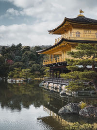 Building by lake against sky