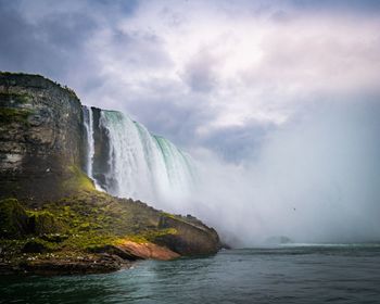 Scenic view of waterfall against sky