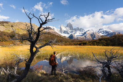 Man standing by lake against sky