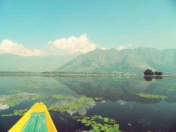 Scenic view of lake by mountains against sky