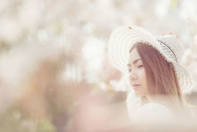 Portrait of young woman looking away outdoors