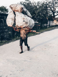 Full length rear view of man walking on road