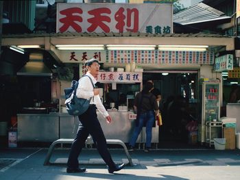 Side view of people walking on street in city