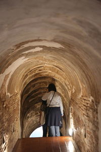 Rear view of man standing in tunnel