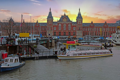 Boats moored in river against buildings in city