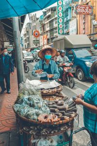 People at market stall in city