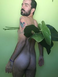 Portrait of young man standing against wall