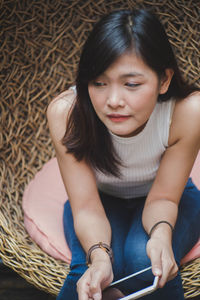 Woman using phone while sitting on seat