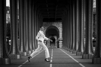 Full length of young woman standing in tunnel in paris 