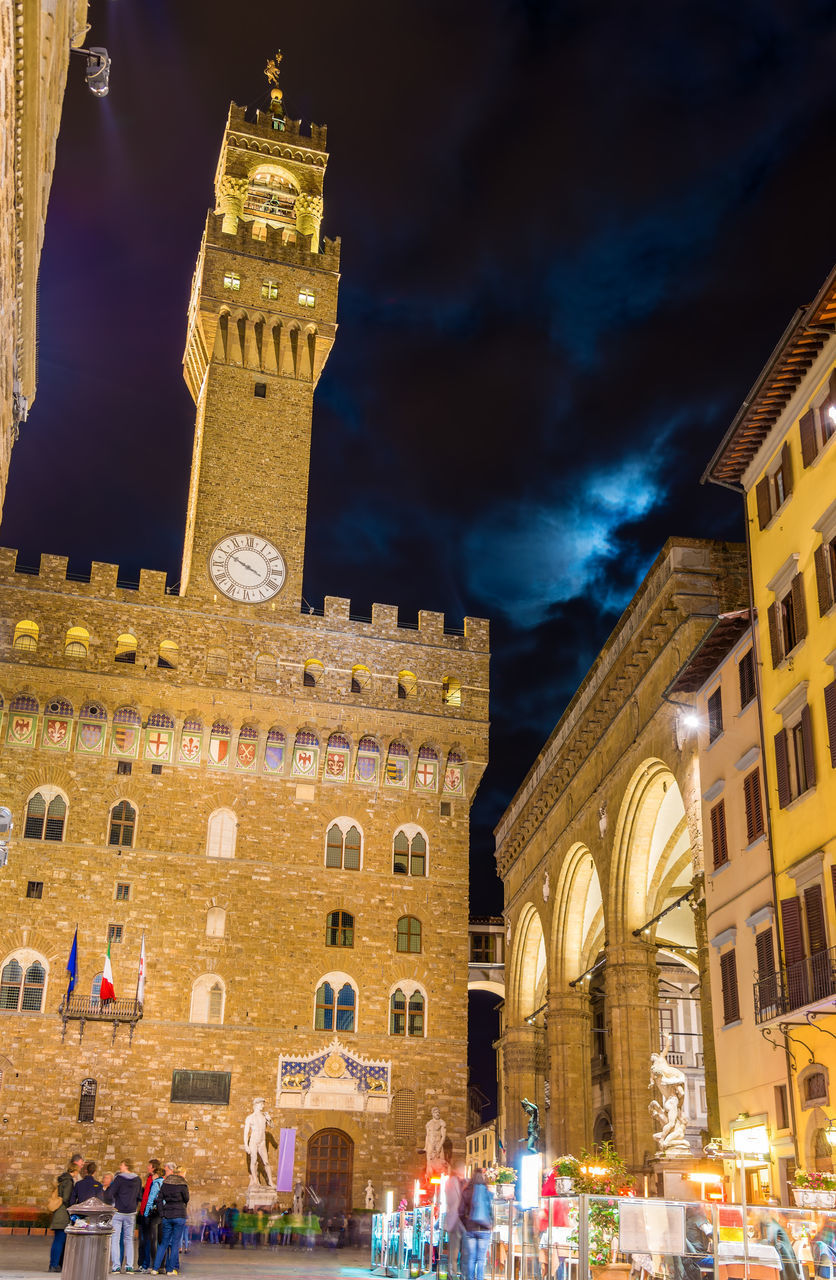 LOW ANGLE VIEW OF ILLUMINATED BUILDINGS AT NIGHT