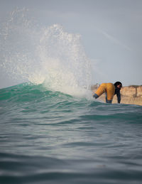 Man surfing in sea against sky