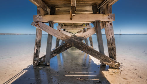 Wooden pier on sea shore against sky