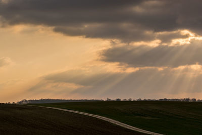 Scenic view of field against cloudy sky