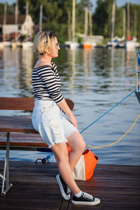 Attractive woman posing on the marina at a sunny summer day at the river