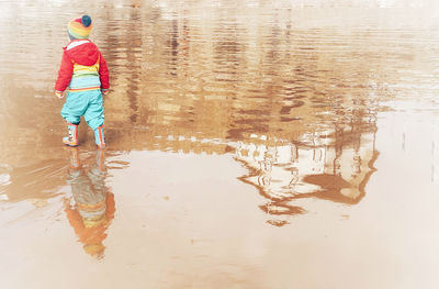 Reflection of man and woman standing in water