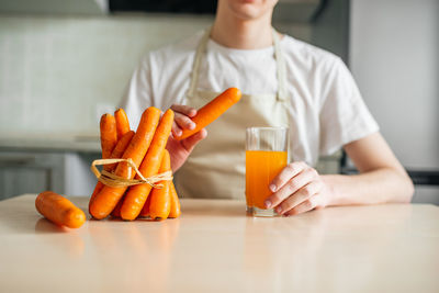 Midsection of man holding ice cream on table