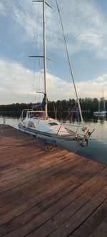 Sailboats moored at harbor against sky