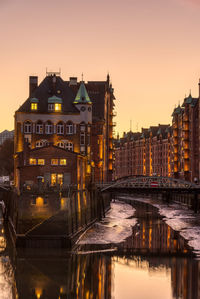 Reflection of buildings in city at sunset