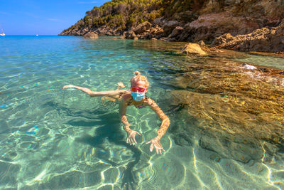 High angle view of woman wearing mask swimming in sea