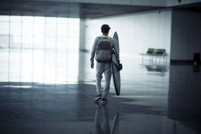 Rear view of man walking on floor in building