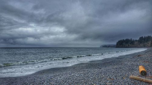 Scenic view of sea against storm clouds