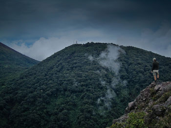 Man standing on mountain against sky