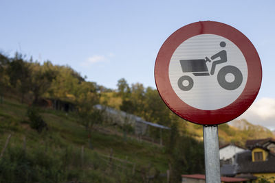 Close-up of road sign against sky