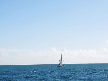 Sailboat sailing on sea against sky